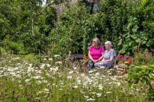 People sat in the Community Orchard at Hudson House, Reeth Information Centre